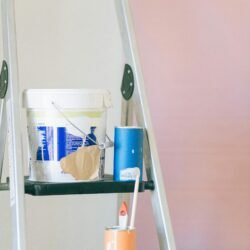 A ladder with painting tools and materials used for home renovation and interior design.